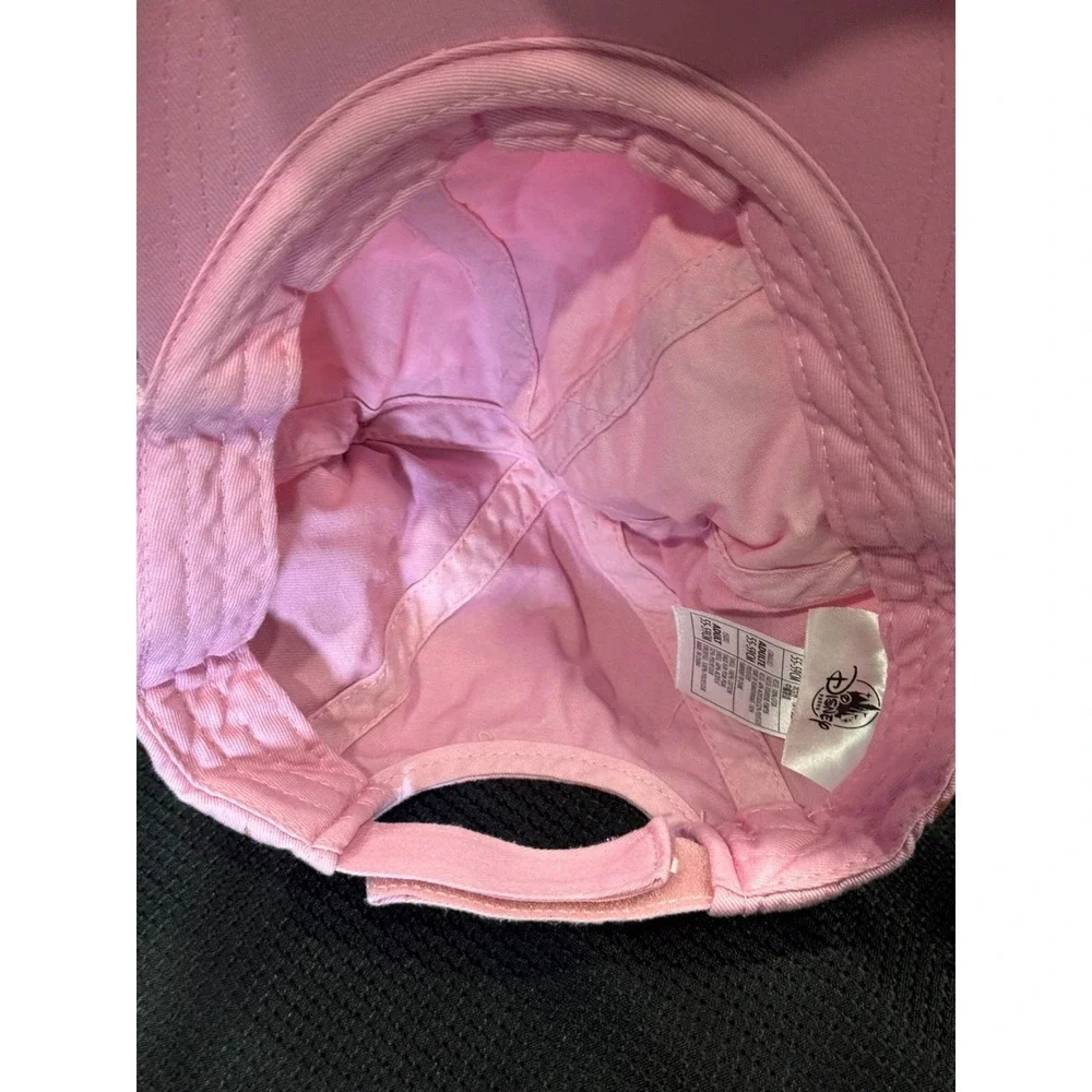 Pink polka-dot cap topped with two fluffy faux fur pom poms